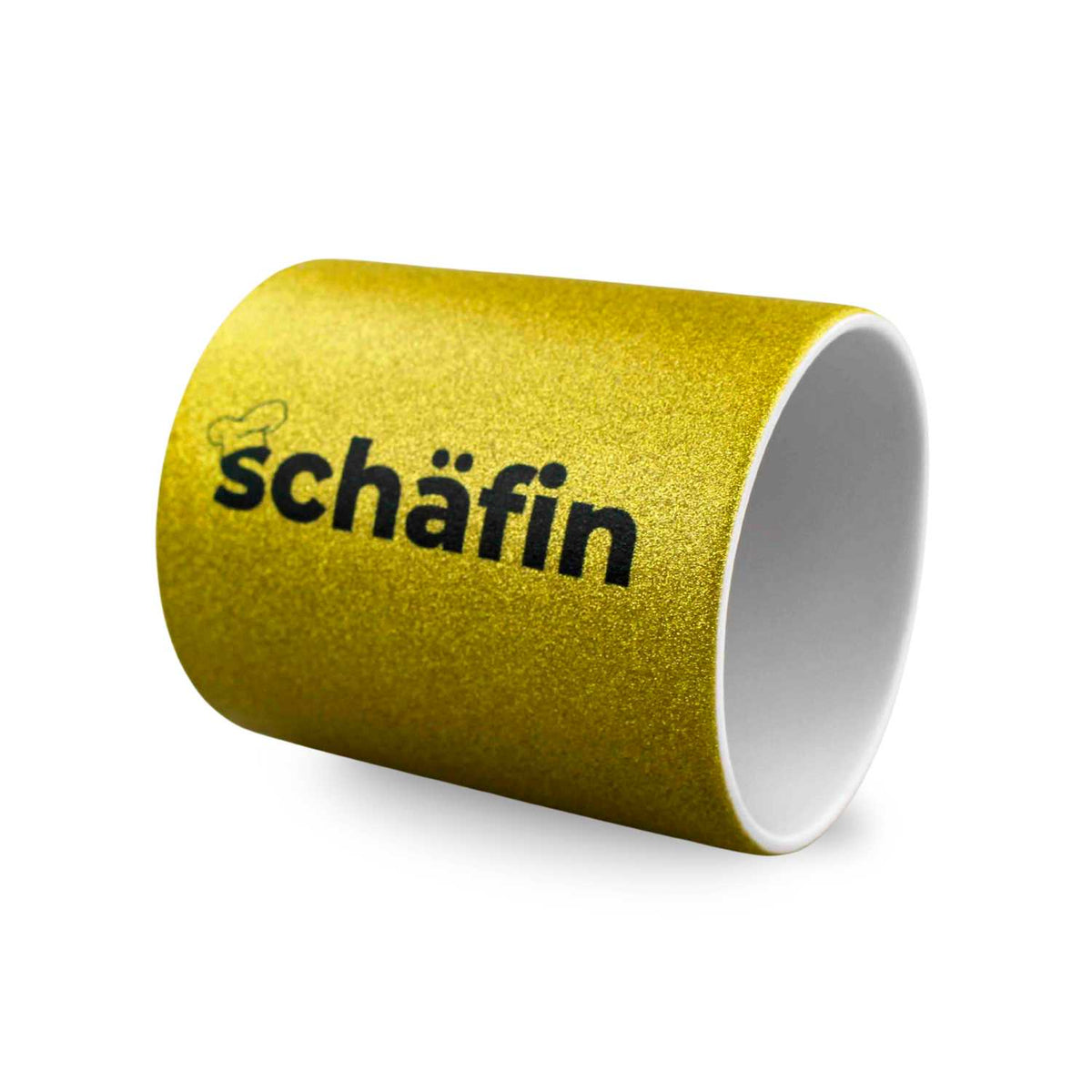 Glitzernder goldener Kaffee Haferl "Schäfin" mit schwarzem Schriftzug und Kochmützen-Symbol auf weißem Hintergrund.
