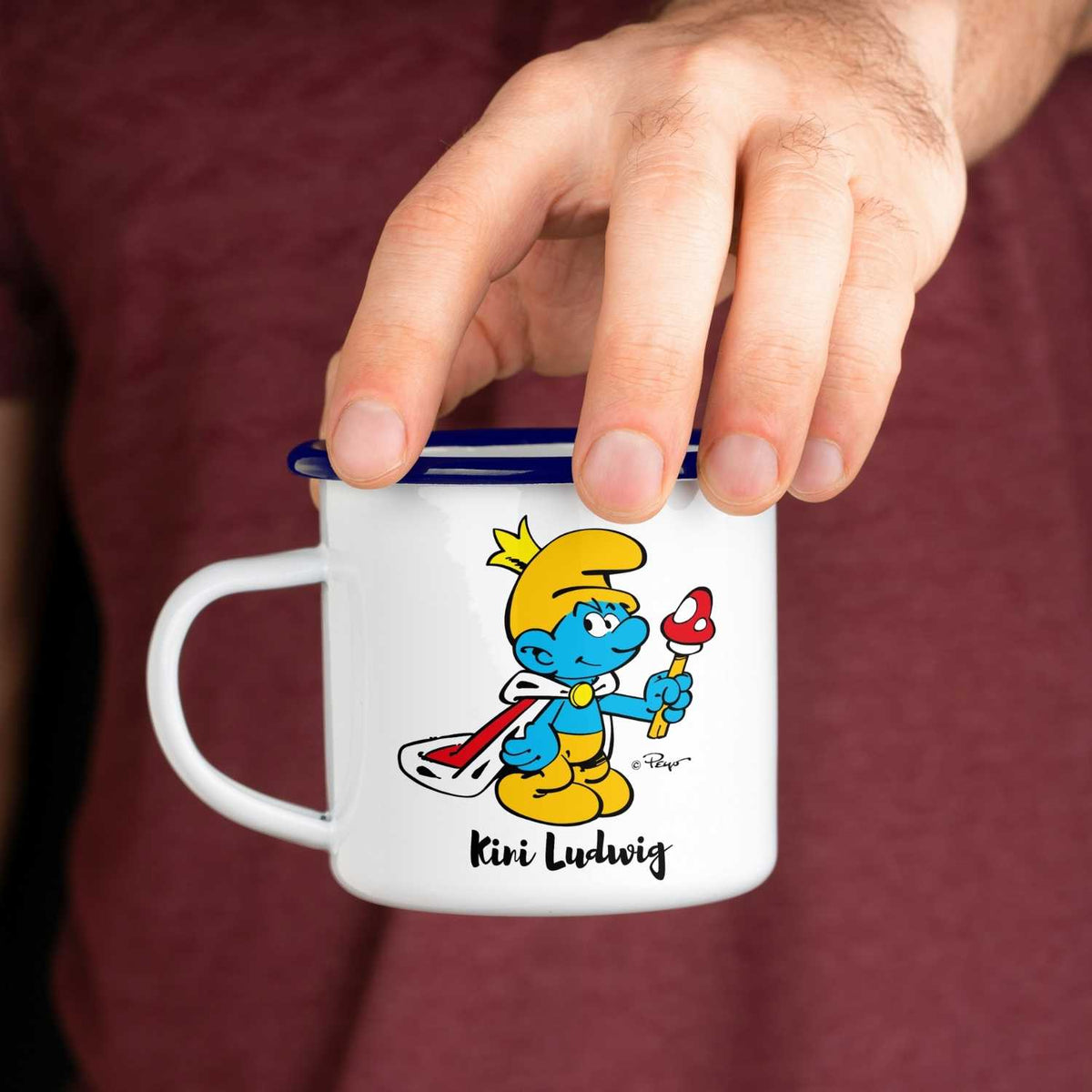 ®Die Schlümpfe Emailletasse Kini personalisiert, weiß mit blauem Rand, in Hand gehalten
