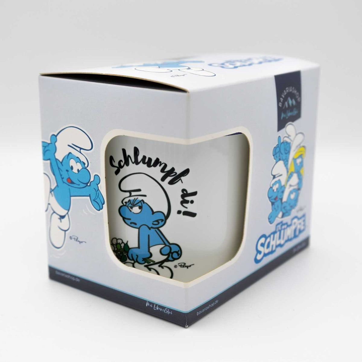 Verpackte ®Die Schlümpfe Tasse Schlumpf di! mit grimmigem Schlumpf und Schriftzug sichtbar im Kartonausschnitt