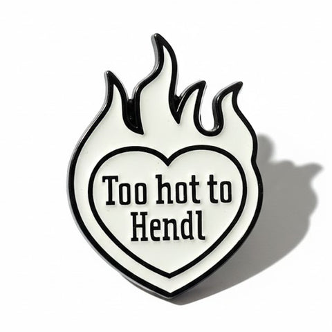 Pin „Too hot to Hendl“: weißes Emaille-Herz mit schwarzen Flammen und Schriftzug, Vorderansicht
