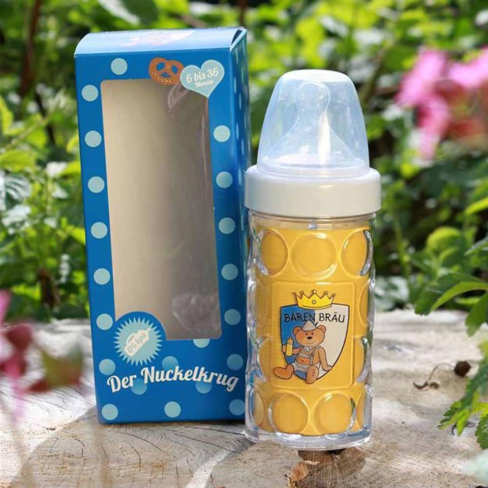 Babyflasche im Maßkrug-Design "Bären Bräu" mit blauem Geschenkkarton auf Holzstamm im Freien