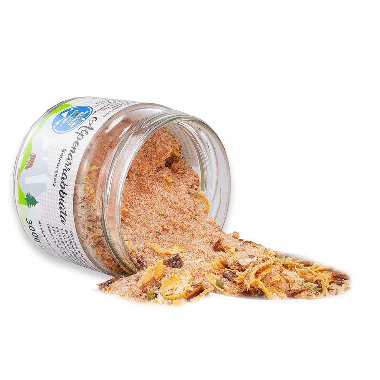 Glasgefäß mit Bayr. Alpenarrabbiata Gewürzsalz, teilweise auf weißem Untergrund verstreut, zeigt Kräuter und Gewürze.