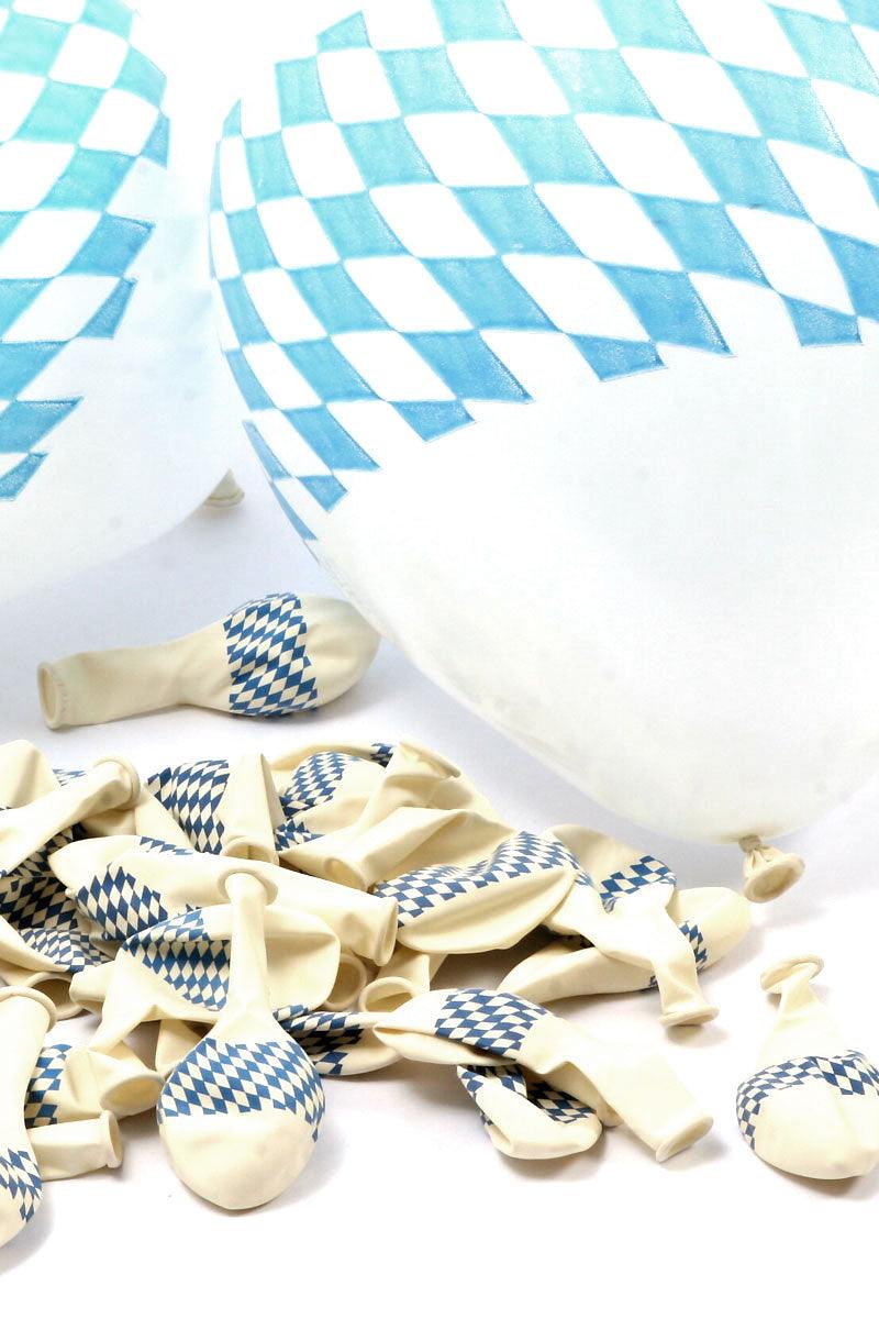 Aufgeblasene und noch verpackte bayerische Luftballons mit blau-weißem Rautenmuster für Oktoberfest-Dekoration