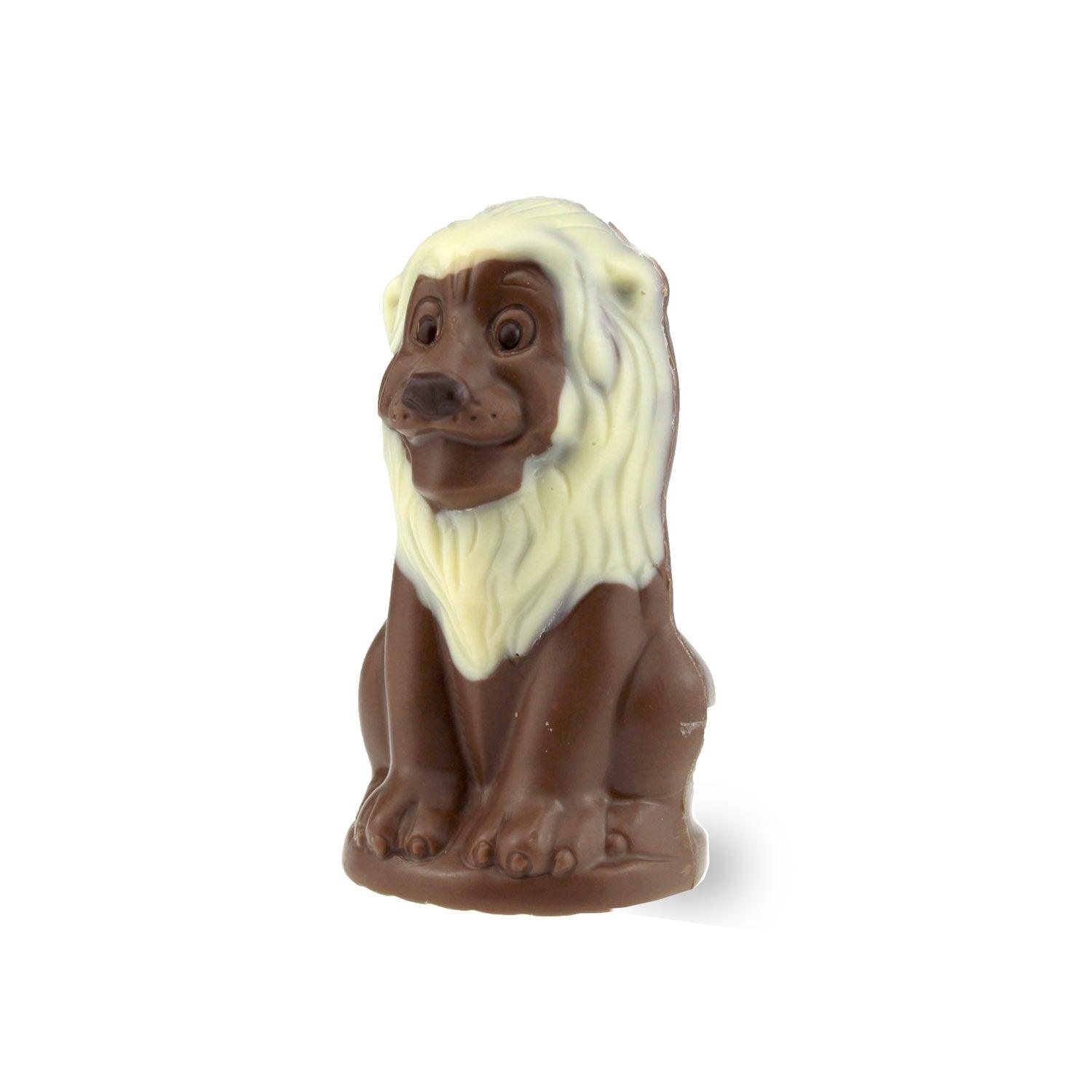 Bayrischer Schoko-Löwe aus Vollmilchschokolade mit heller Schokomähne, sitzend, auf weißem Hintergrund.
