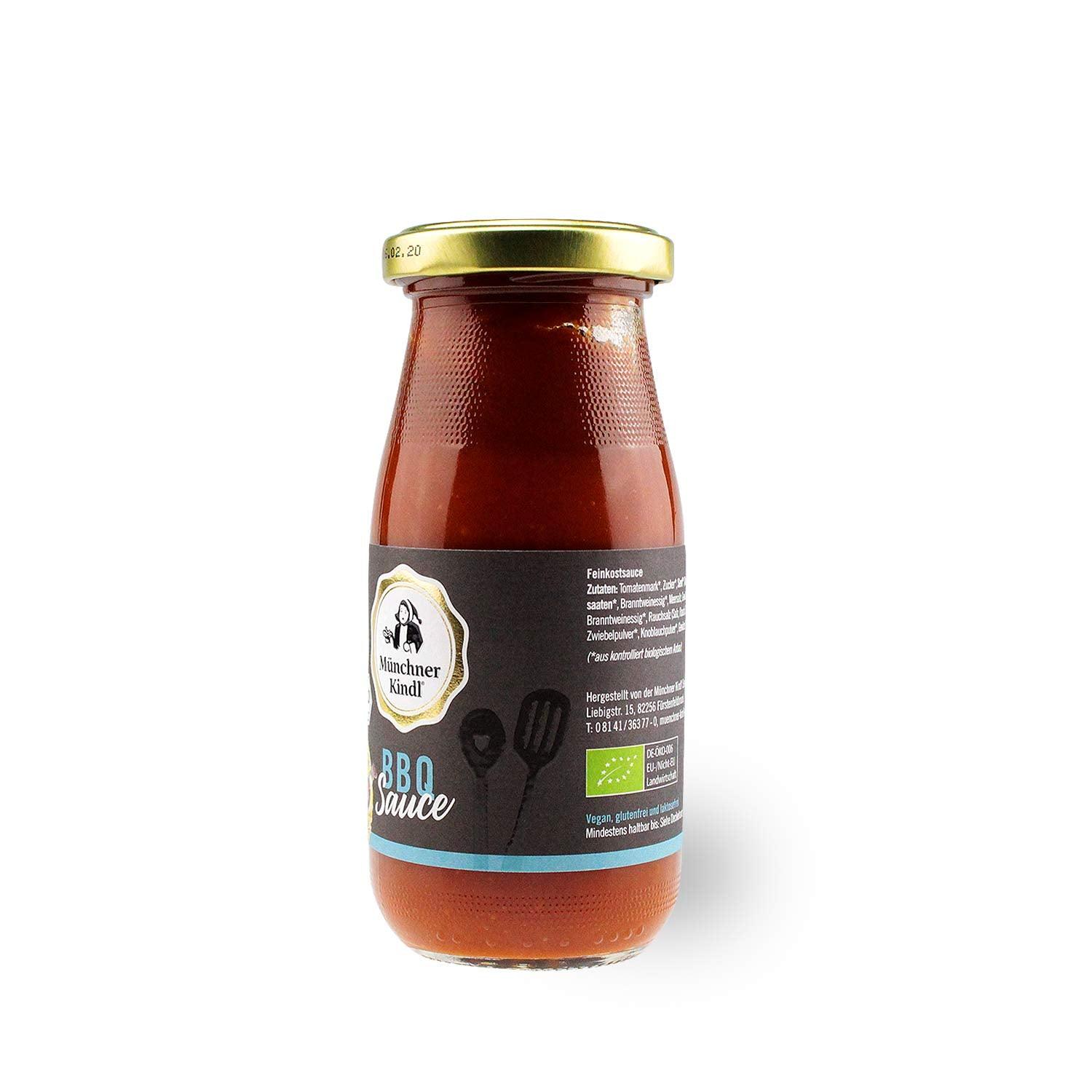 Braune Glasflasche mit schwarzem Schraubverschluss, Etikett mit Aufschrift „BIO Grillsauce“ und bayerischem Motiv.