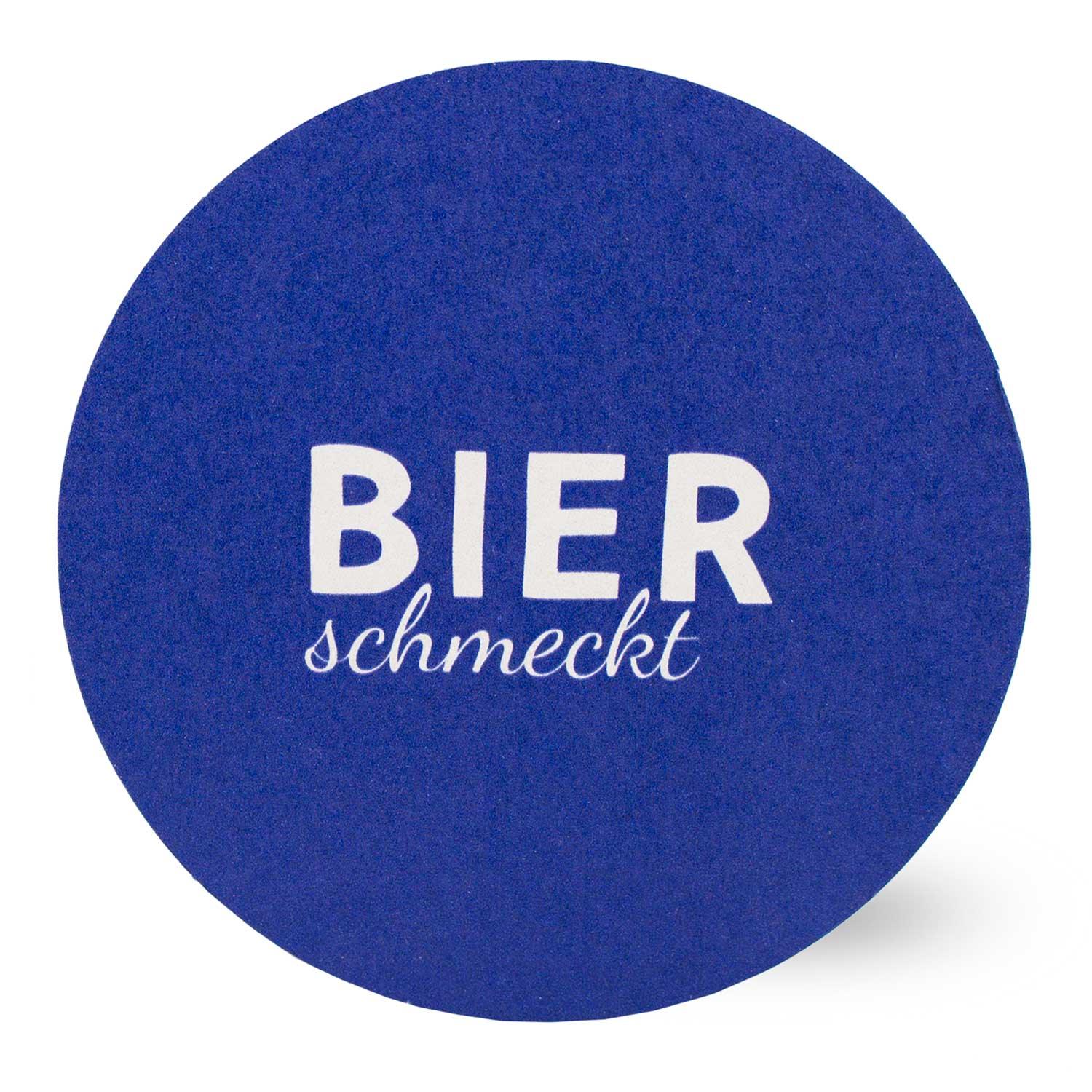 Runder Bierfilz in leuchtendem Blau mit weißer Aufschrift Bier schmeckt.