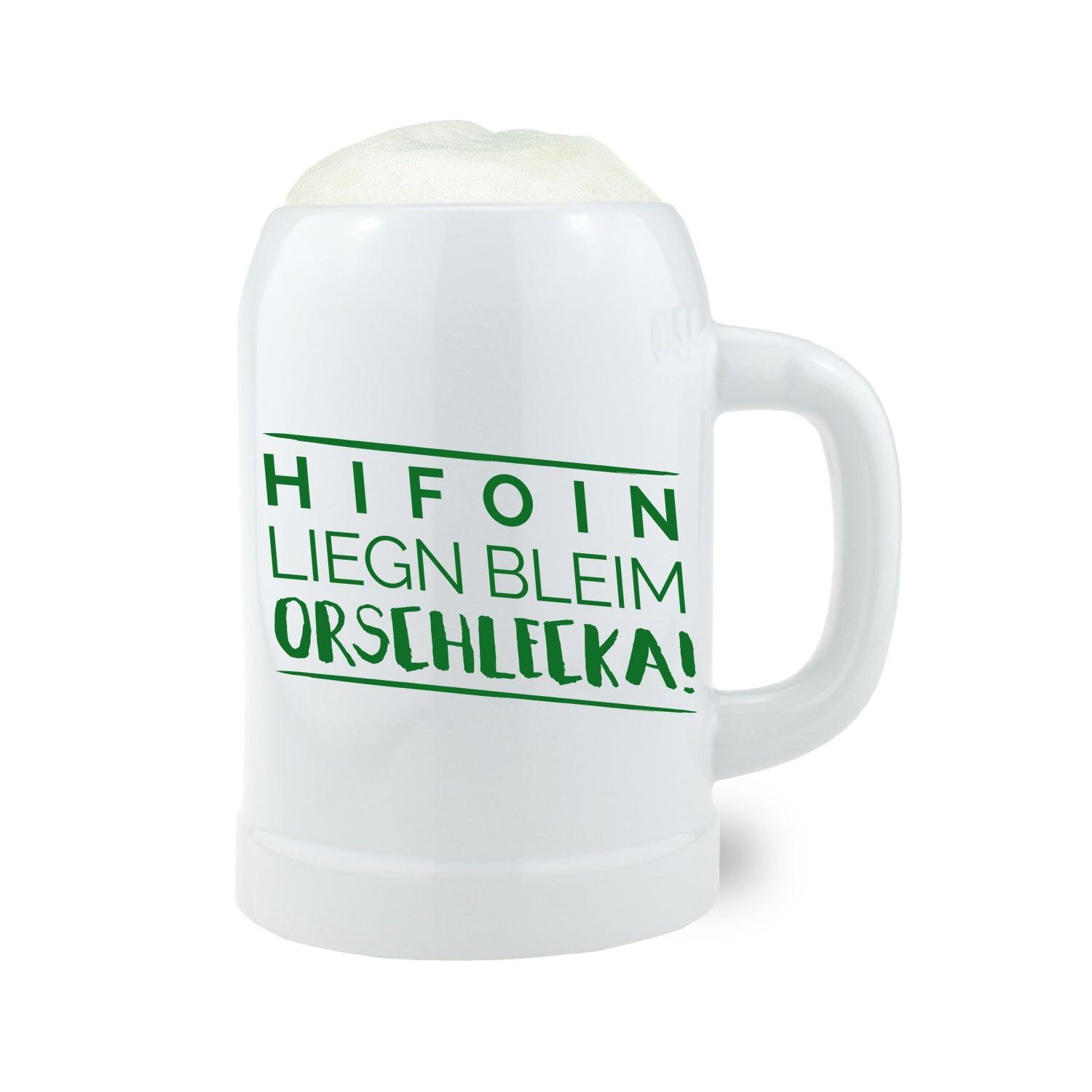 Weißer Bierkrug Hifoin - liegn bleim mit grünem Aufdruck, gefüllt mit Schaum, auf weißem Hintergrund.