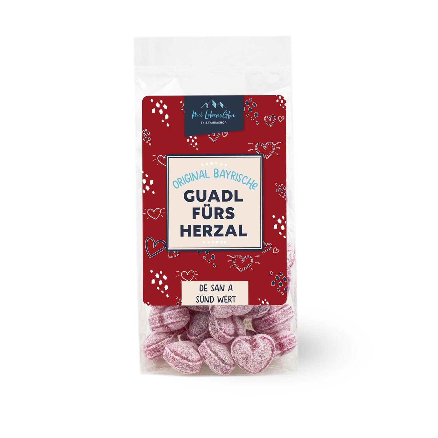 Transparente Tüte Boarische Herzal-Guadl mit pinken herzförmigen Bonbons und rotem Etikett.