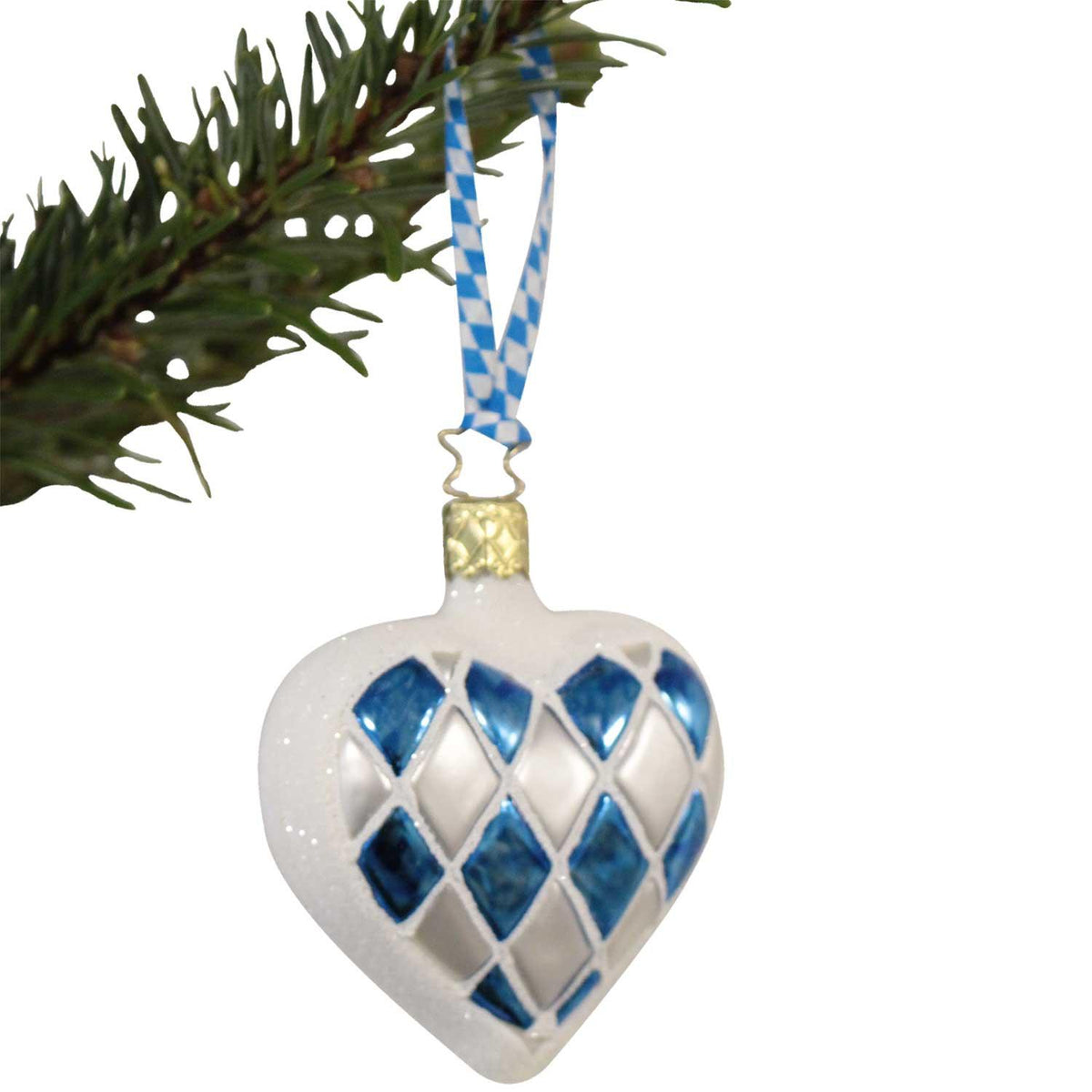 Weißer Herz-Weihnachtsbaumschmuck mit blau-weißem Rautenmuster und schimmerndem Finish, an einem Tannenast hängend.