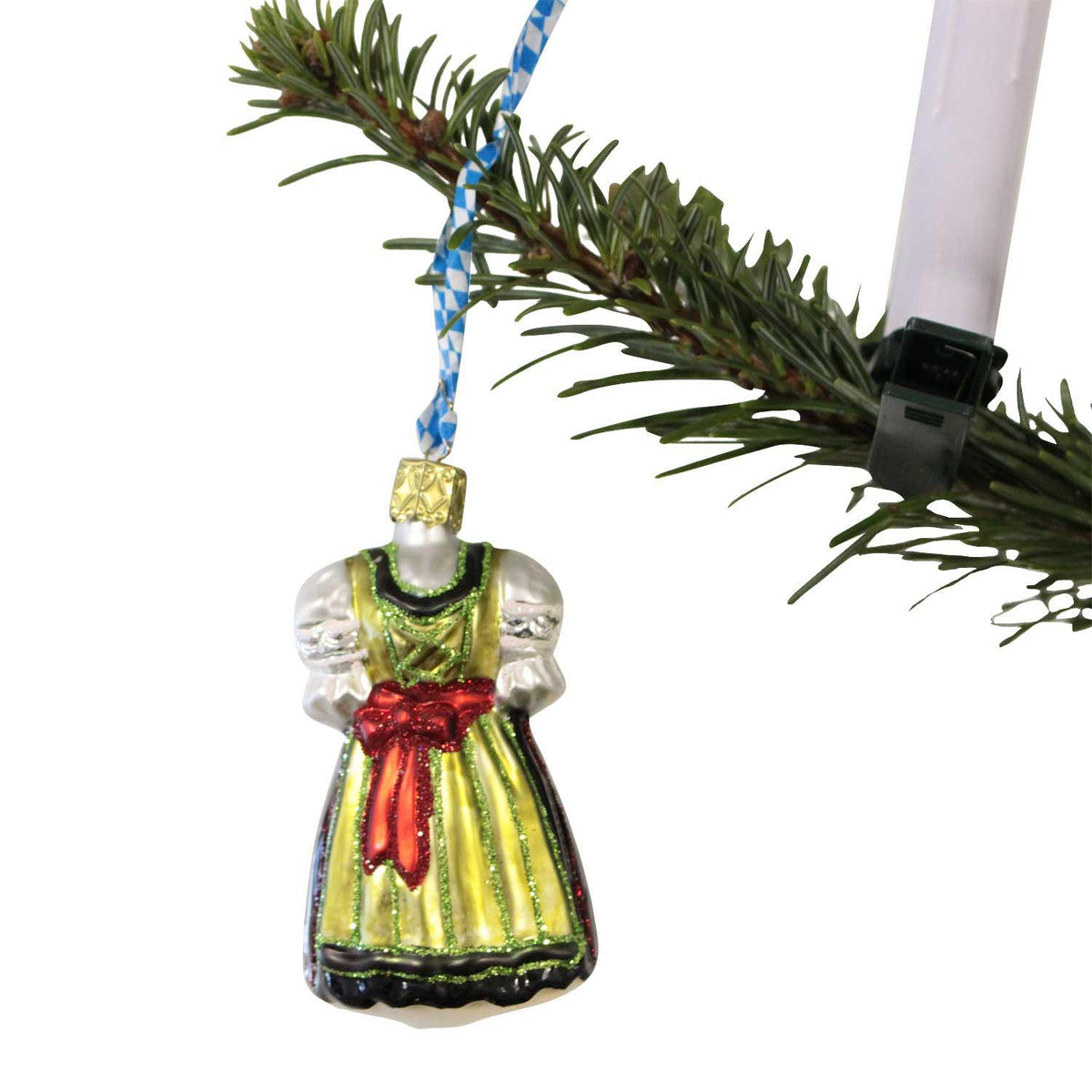 Bayerischer Dirndl-Weihnachtsbaumschmuck aus Glas mit gelbem Kleid und roter Schleife, hängt an Fichtenzweig.