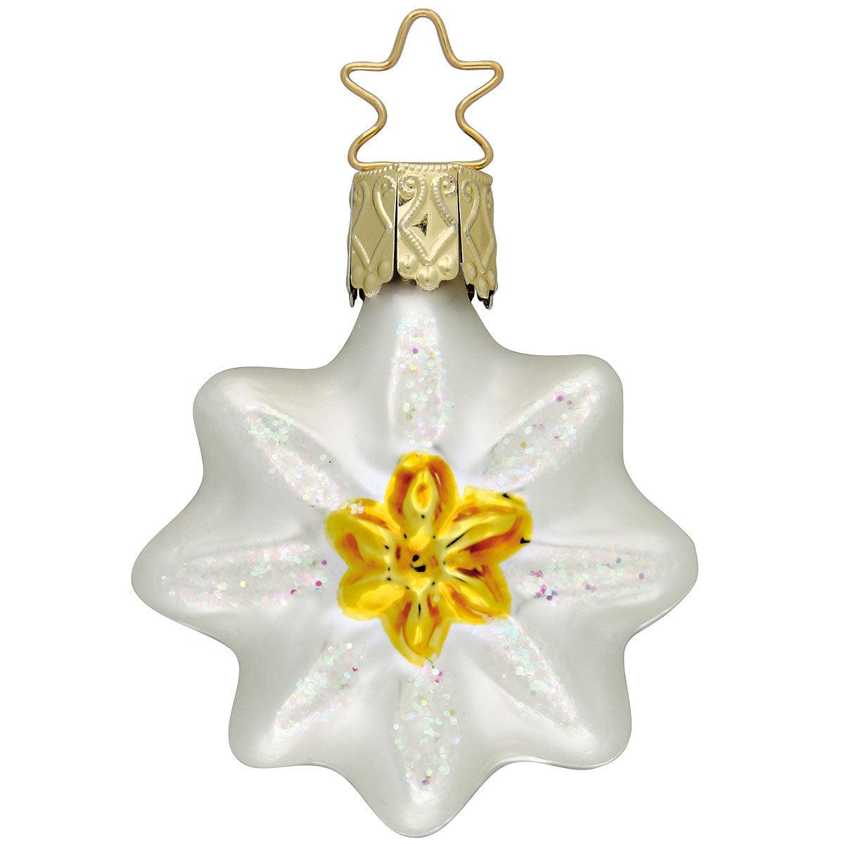 Weißer Edelweiß-Christbaumschmuck aus Glas mit leuchtend gelber Blüte in der Mitte, verziert mit Glitzer.