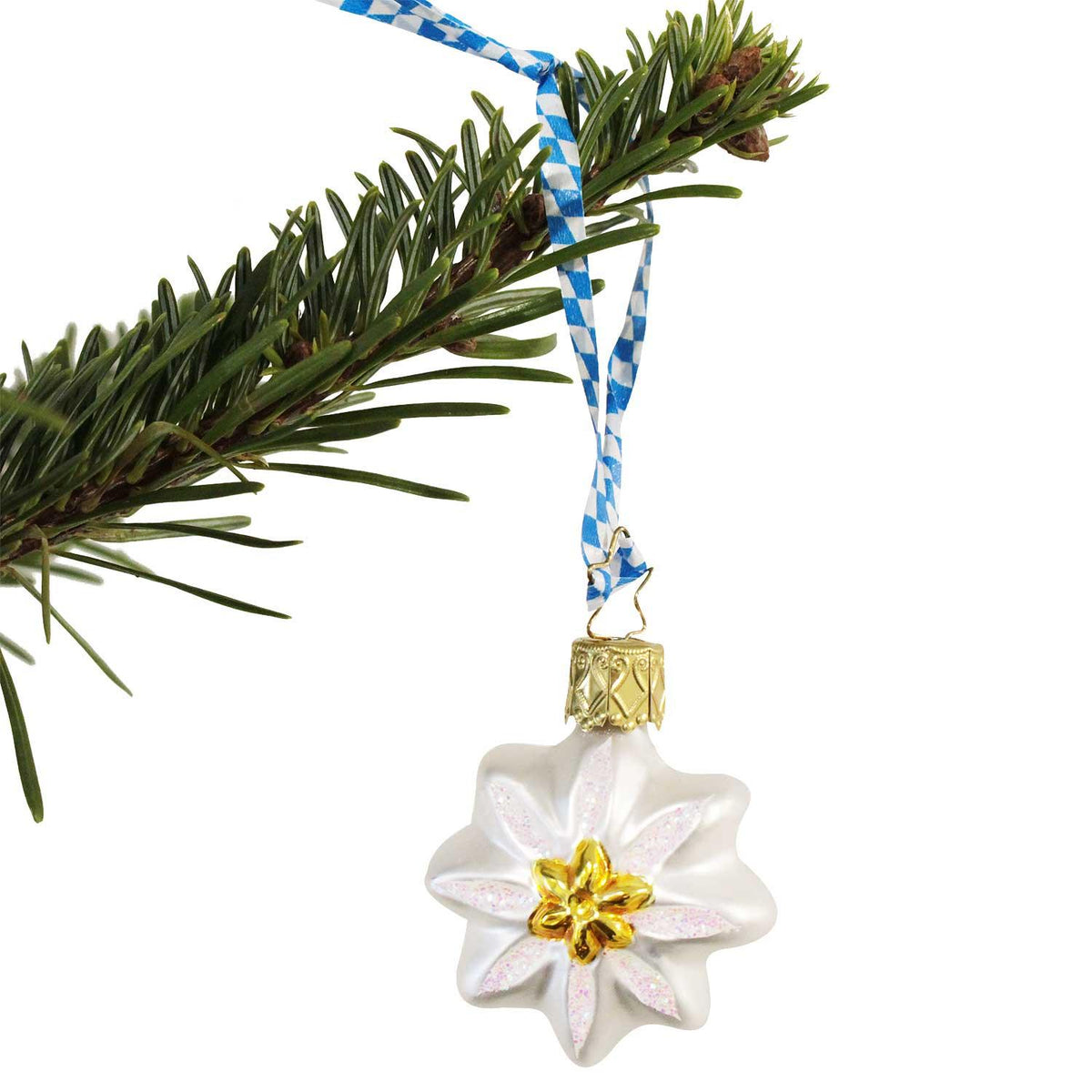 Gläserner Christbaumschmuck in Edelweißform mit goldener Mitte und bayerischem blau-weißem Band am Tannenzweig.