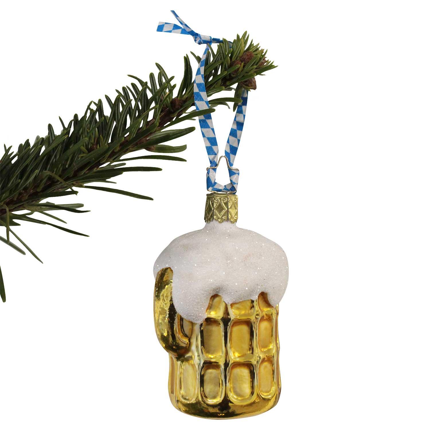 Christbaumschmuck in Bierkrug-Form mit Schaumkrone, bayerischem Band an Tannenzweig hängend.