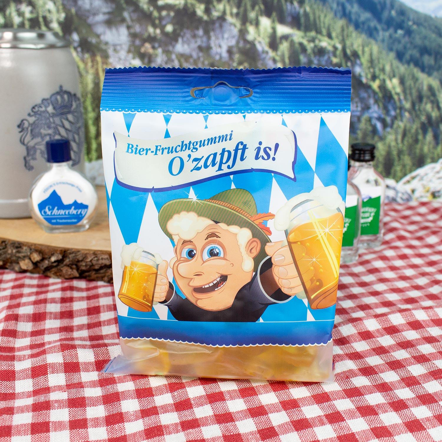Verpackung Bier-Fruchtgummi O'zapft is mit Comic-Motiv auf rot-weiß kariertem Tisch.