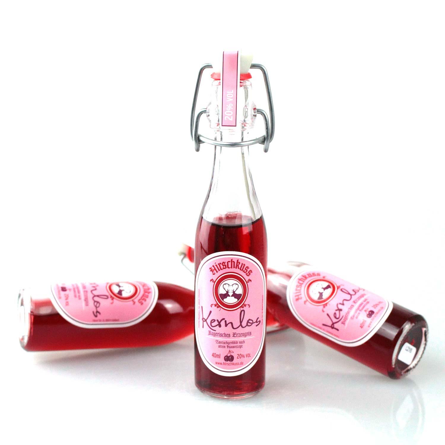Drei kleine Flaschen kernloser Zwetschgenlikör "Kernlos" von Hirschkuss mit rosa Etiketten auf weißem Hintergrund.