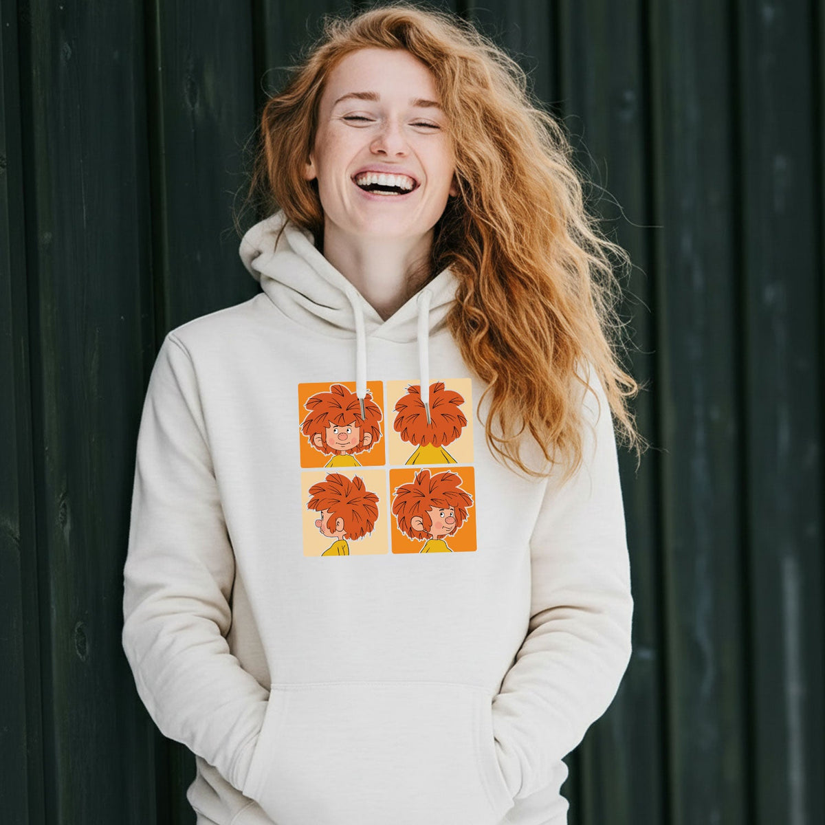 Lachende Frau mit rotem Haar trägt beigen Pumuckl Hoodie Schnappschuss mit Pumuckl Comic-Motiv.