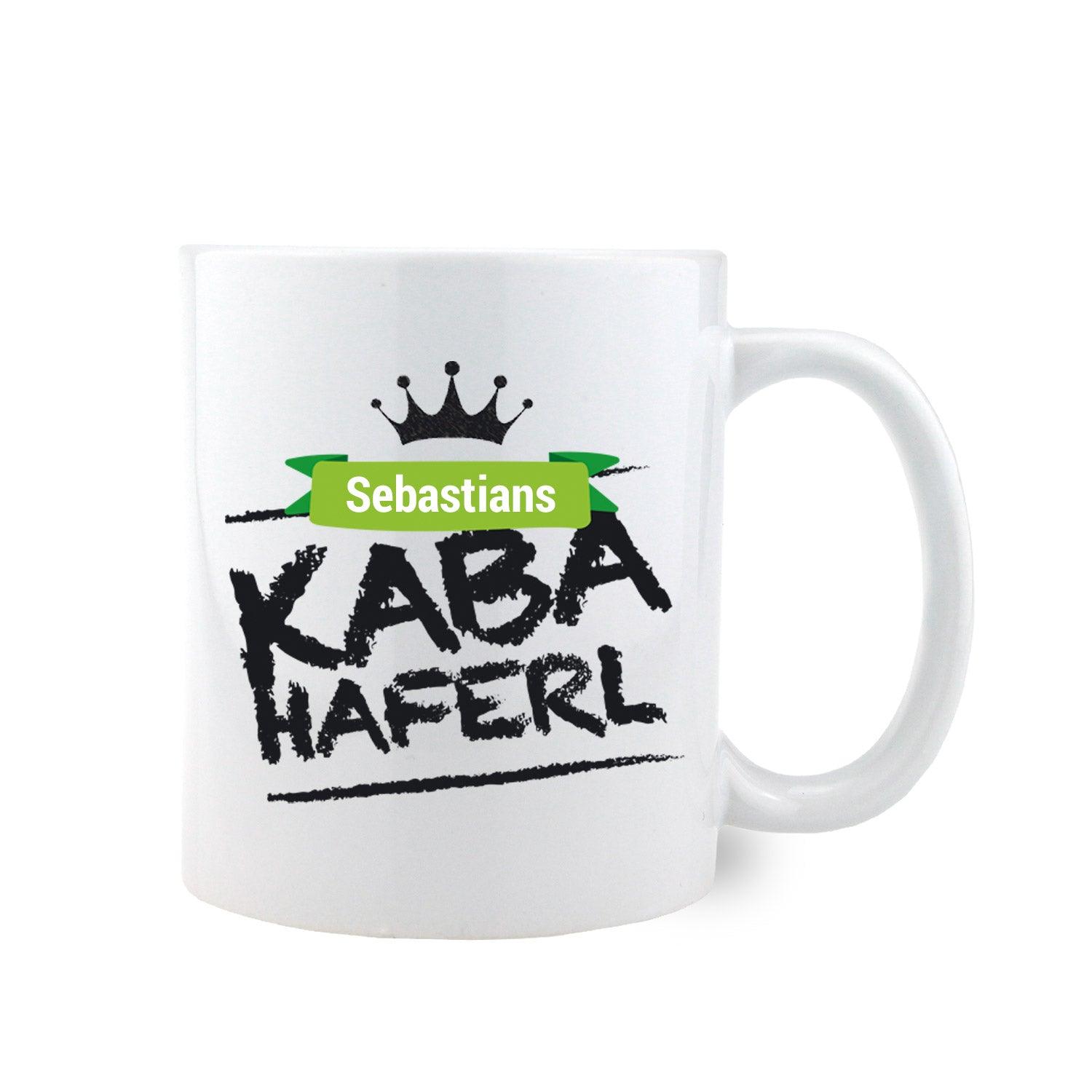 Weißes Kaba-Haferl mit Wunschname "Sebastians", grüner Krone und schwarzer Schrift.