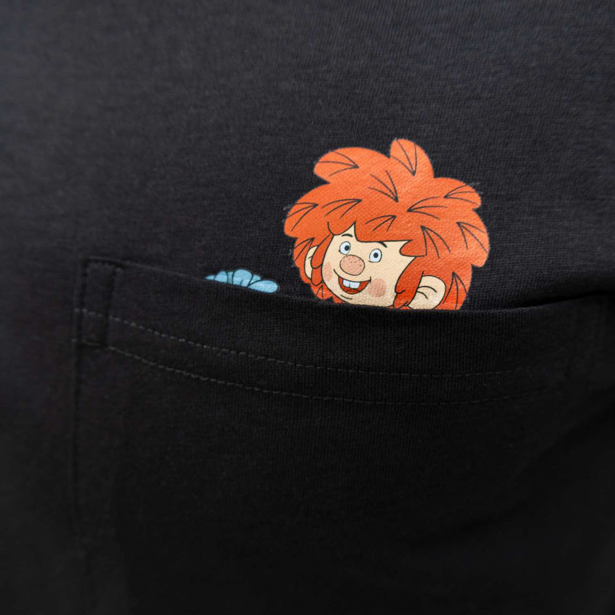 Schwarzes Pumuckl Shirt mit lachendem Pumuckl, der neugierig aus der Brusttasche schaut