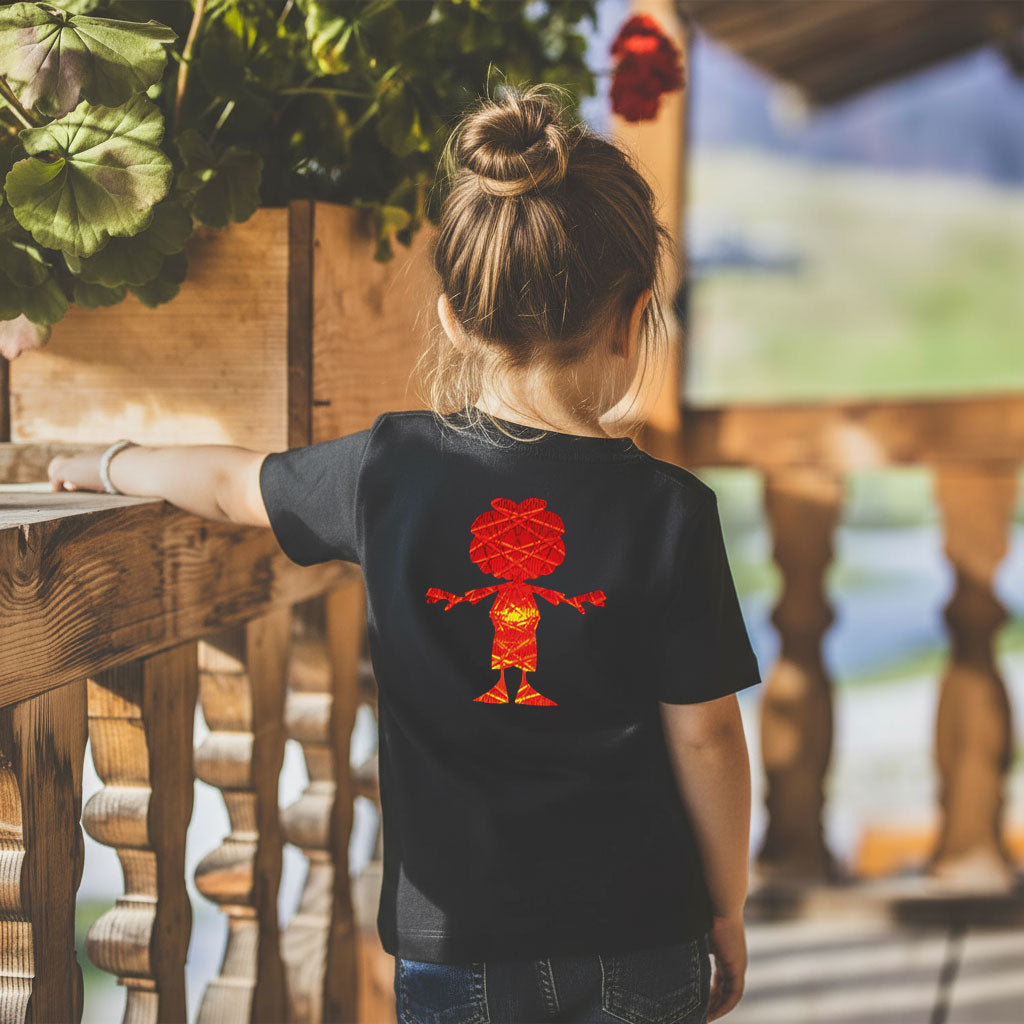 Kind von hinten mit schwarzem Pumuckl Kinder T-Shirt Ampel-Edition auf einem Holzbalkon stehend.