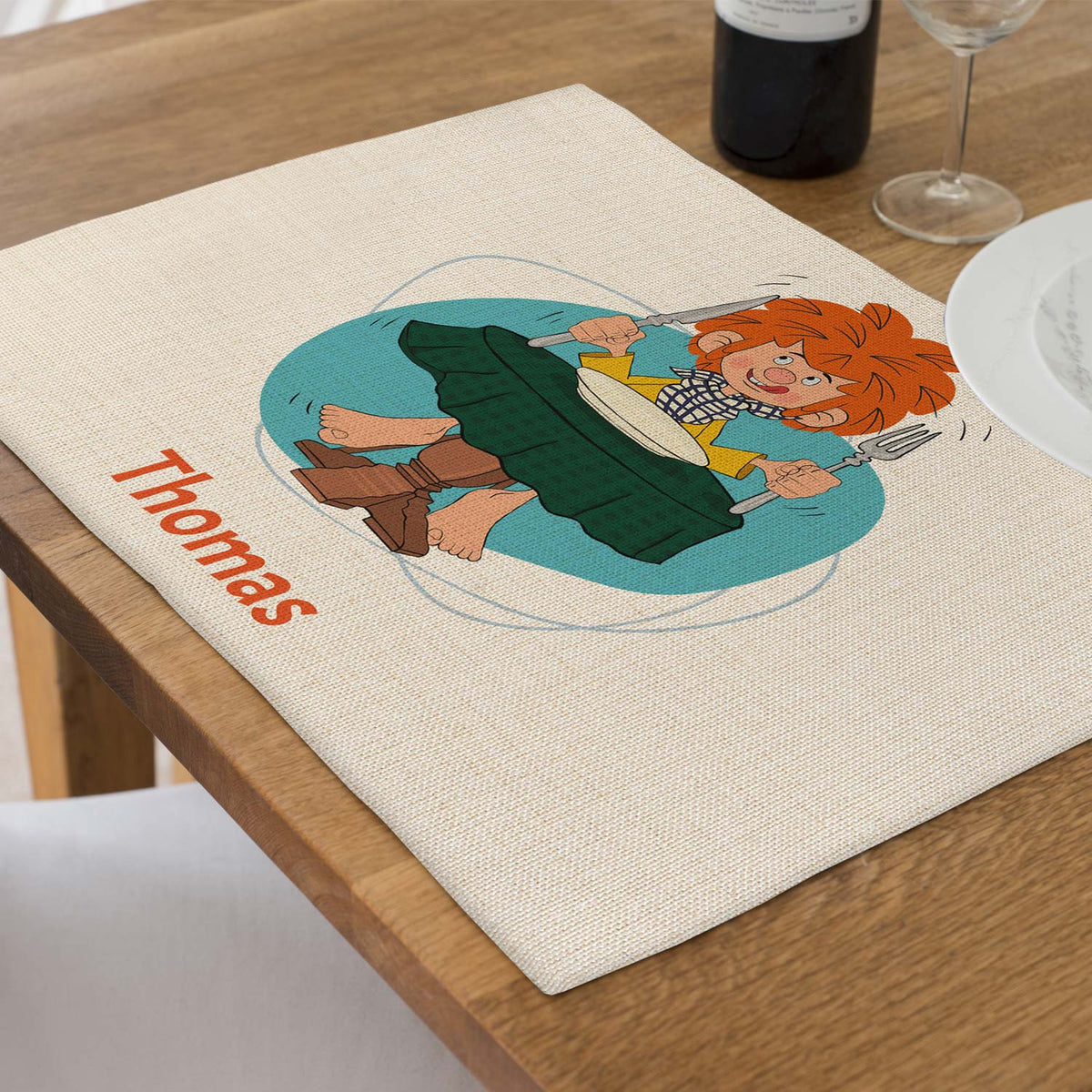 Abwaschbares Pumuckl Tischset mit Wunschname "Thomas" und fröhlichem Pumuckl-Motiv auf Holztisch.