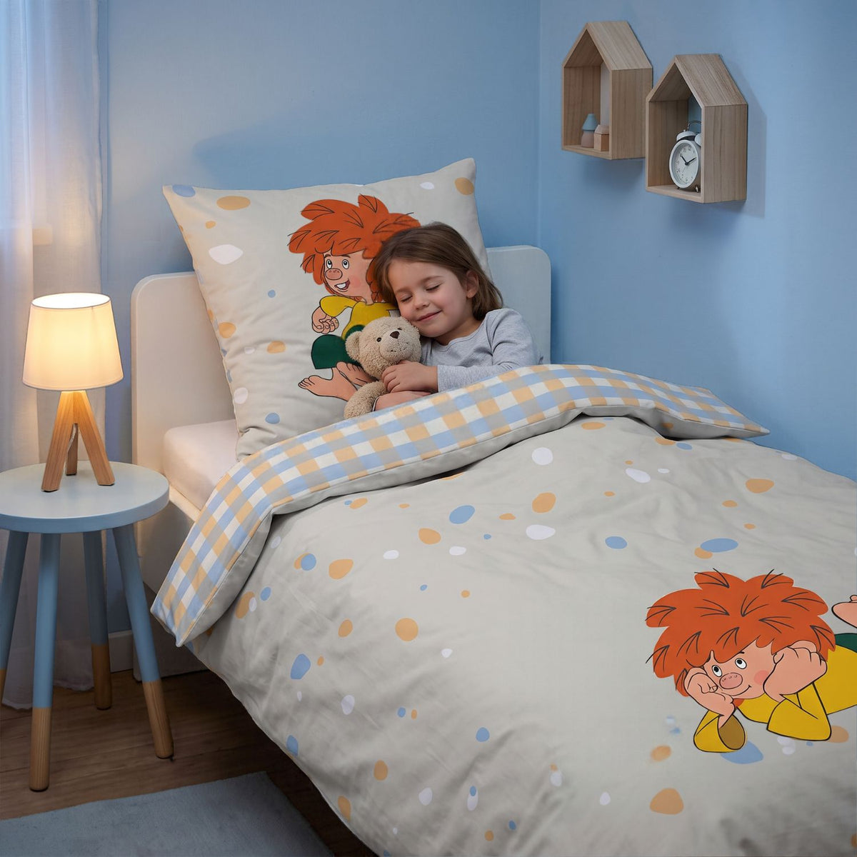 Mädchen kuschelt mit Teddy in der Pumuckl Bettwäsche „Gute Nacht“, Karo-Rückseite umgeschlagen