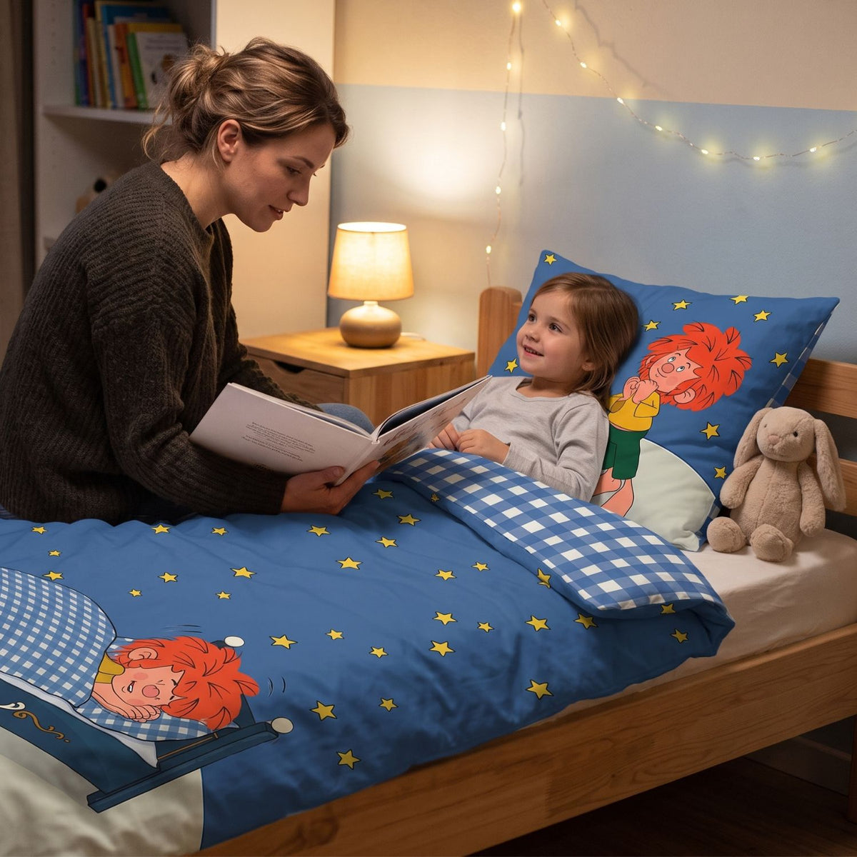 Mama liest ihrer Tochter im Bett mit Pumuckl Bettwäsche „Träum schön“ vor