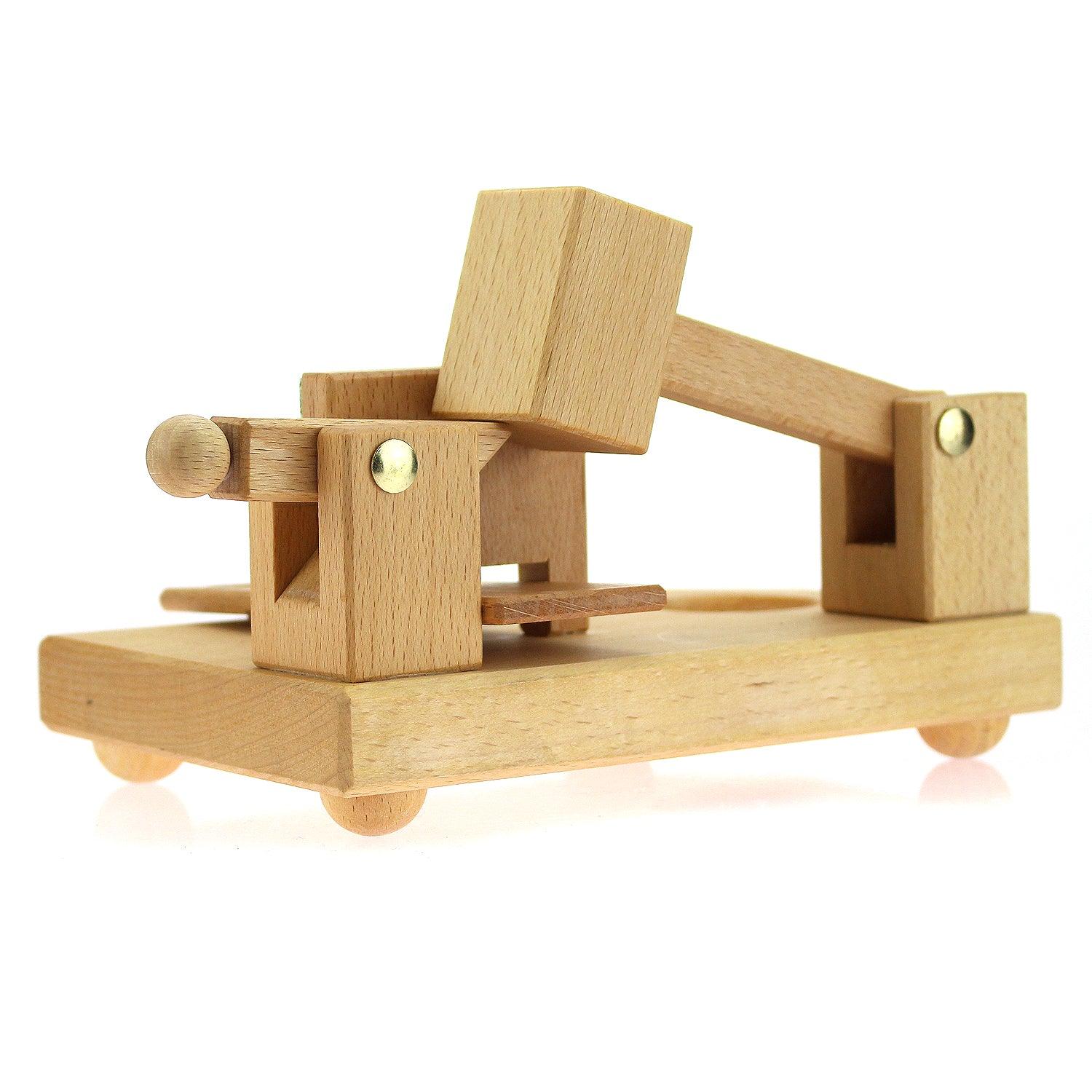 Nussknacker-Spielzeug aus hellem Holz mit Hammer und Plattform auf vier kleinen Kugelfüßen, traditionell.