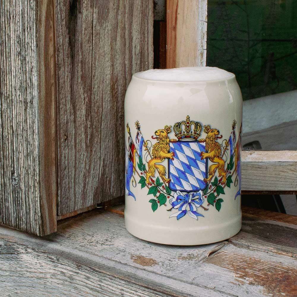 Steinkrug für Bier mit Bayern-Wappen auf einer alten Holzfensterbank
