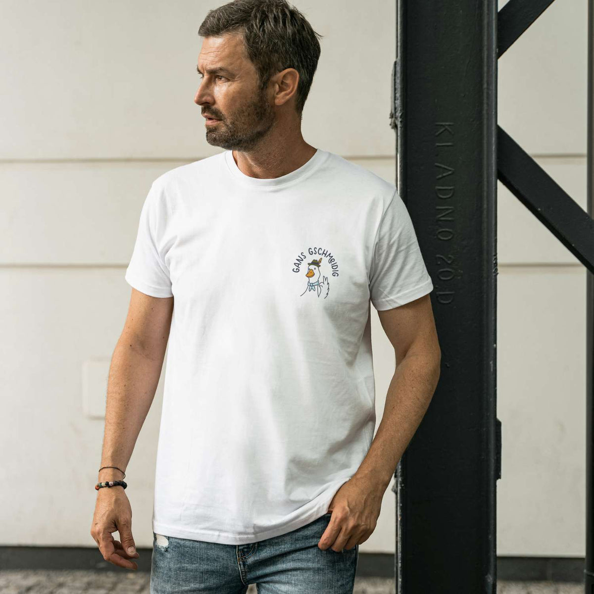Herren T-Shirt Gans gschmeidig in Weiß mit locker sitzendem Rundhals und Gänse-Brustprint, lässig getragen.