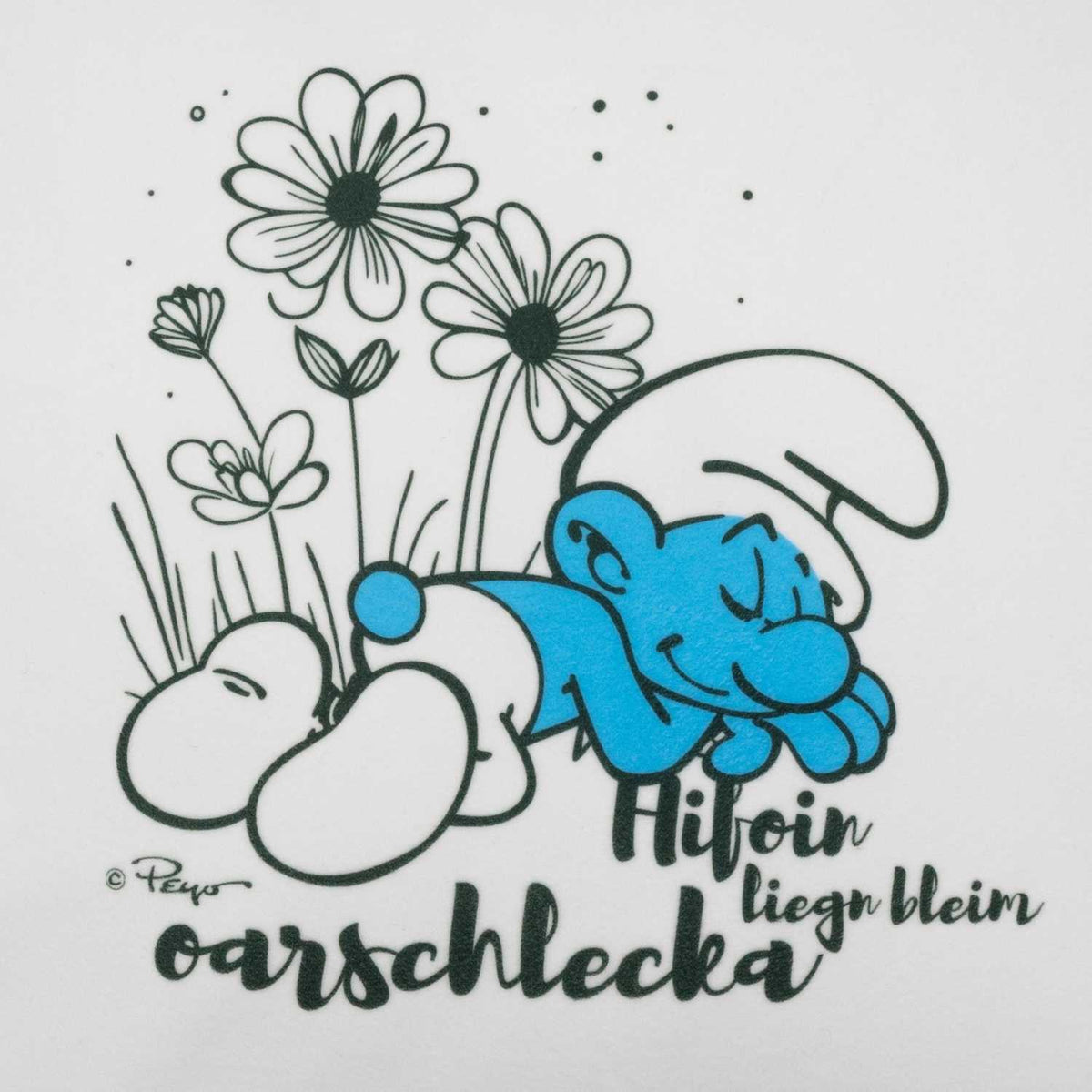 Schlumpf "Hifoin, liegn bleim, oarschlecka" Kuschelkissen Motiv mit schlafendem Schlumpf im Blumenfeld.