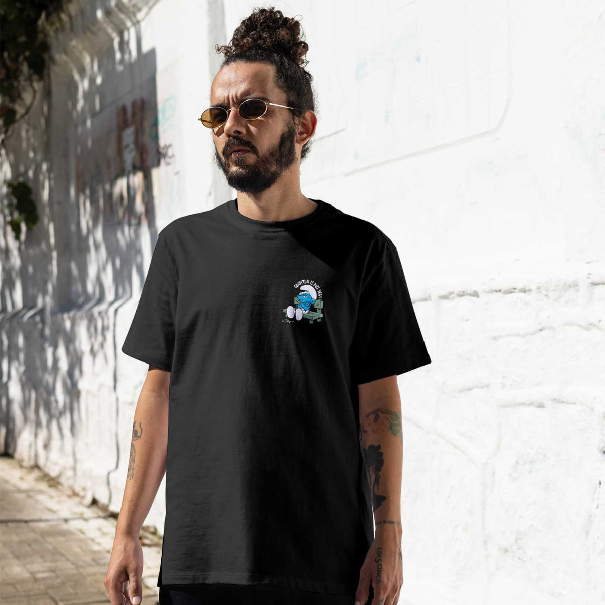 Modischer Mann trägt schwarzes Schlümpfe Herren T-Shirt Grantln is mei Yoga mit Schlaubi Schlumpf Motiv.
