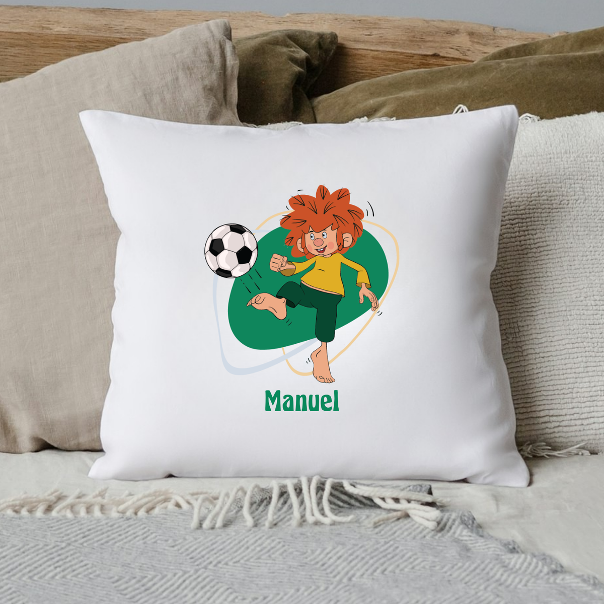 Weißes Pumuckl Fußball Kissen mit Cartoon-Meister Eder, der einen Fußball kickt, personalisiert mit "Manuel".