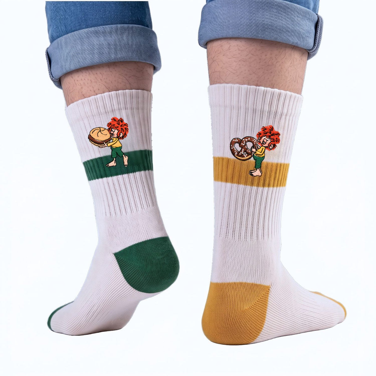 Pumuckl Tennissocken 2er-Set getragen: links grüne Socke mit Pumuckl und Leberkassemmel, rechts senfgelbe Socke mit Pumuckl und Brezn