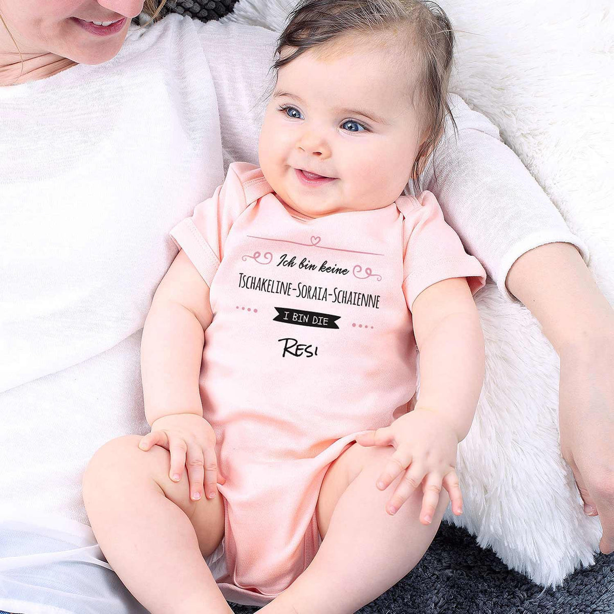 Fröhliches Baby in pinkem Baby Body I bin die Resi mit lustigem Spruch, perfekt für Mädchen.