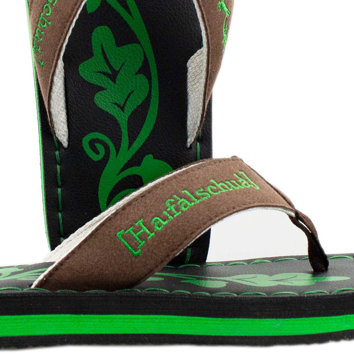 Nahaufnahme Trachten Flip Flops Haferlschuh: grün gestickter Haferlschuh-Schriftzug am Riemen und Eichenlaub-Print auf dem Fußbett