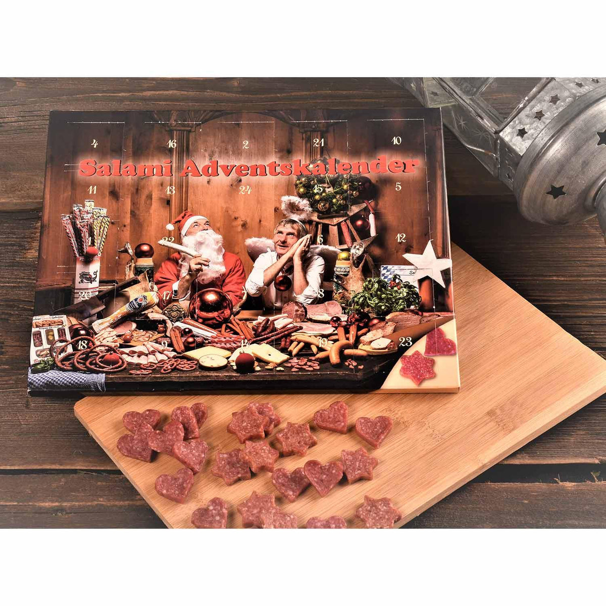 Bayerischer Salami Adventskalender auf Holzhintergrund, daneben herz- und sternförmige Salamischeiben auf Brett.