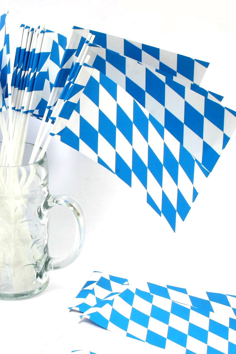 Miniatur-Bayernfahnen in Blau-Weiß im Maßkrug, teils auf dem Tisch für Partydekoration.