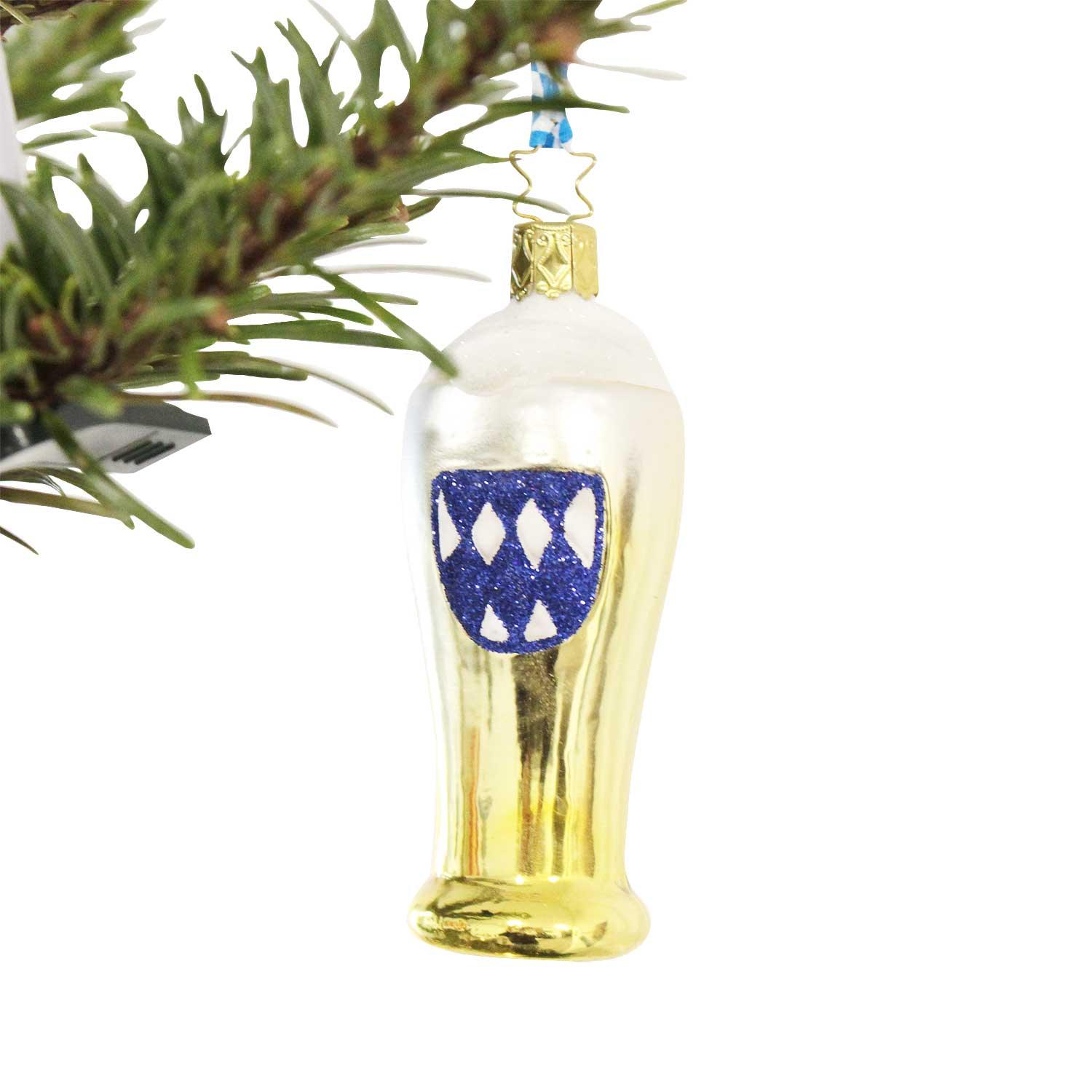 Glänzende Bierglas Christbaumkugel gold mit weißem Schaum und blau-weißem Rautenmuster am Weihnachtsbaum.