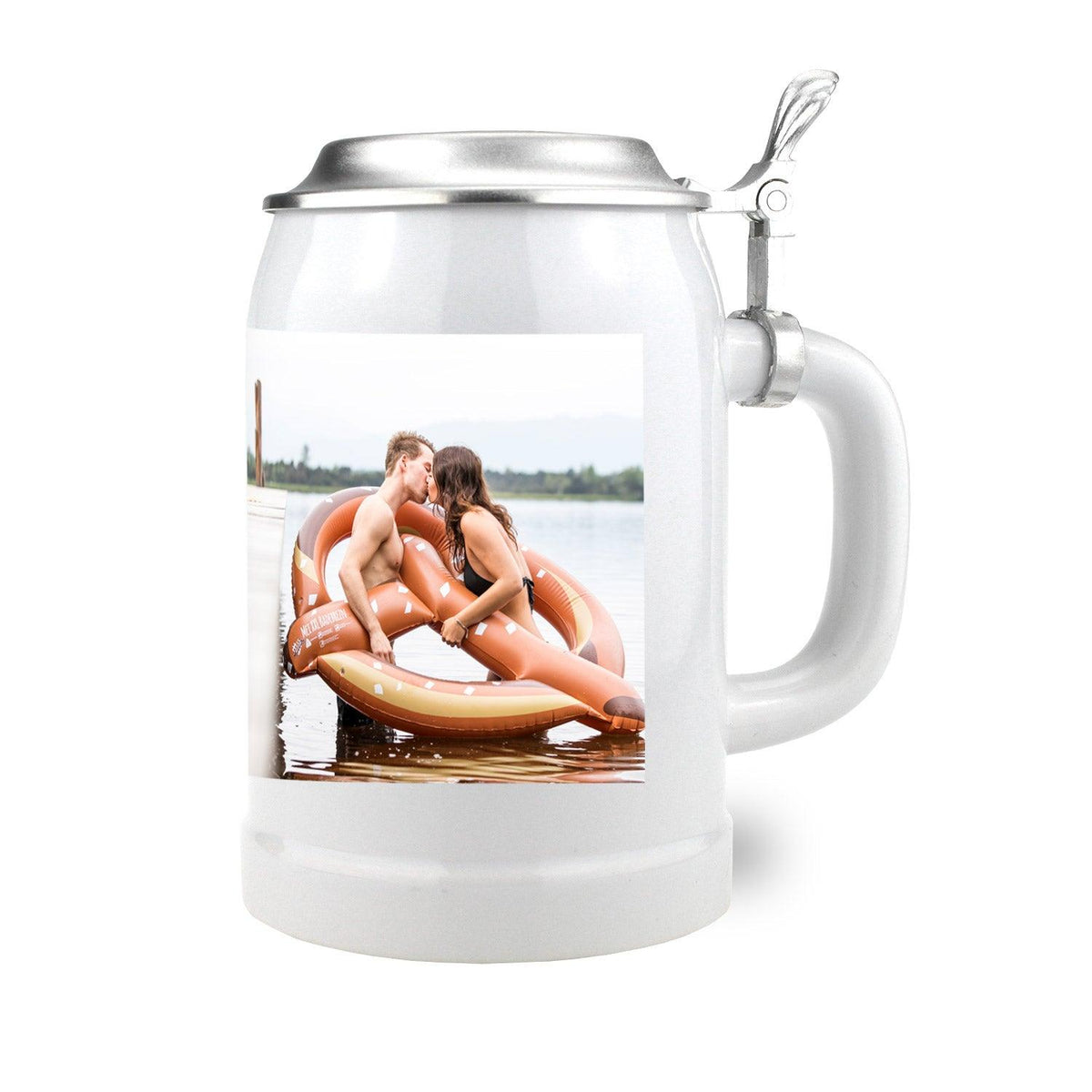 Weißer Bierkrug mit scharniertem Zinndeckel, verziert mit einem Foto eines küssenden Paares auf einer Brezel-Luftmatratze im See.