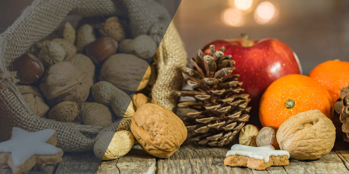 Rustikale Holztisch-Dekoration mit Haselnüssen, Walnüssen, Tannenzapfen, Äpfeln, Mandarinen und Zimtsternen für Weihnachten.