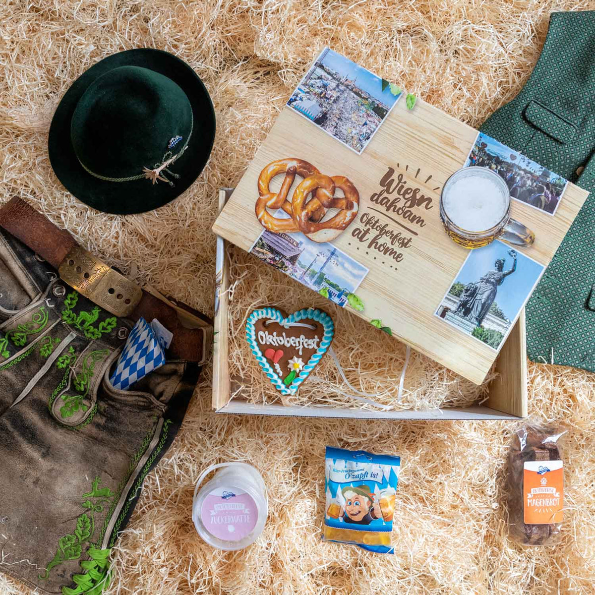 Oktoberfest Geschenkkorb mit Lebkuchenherz, bayerischen Süßigkeiten, Hut und Lederhose auf Holzwolle.