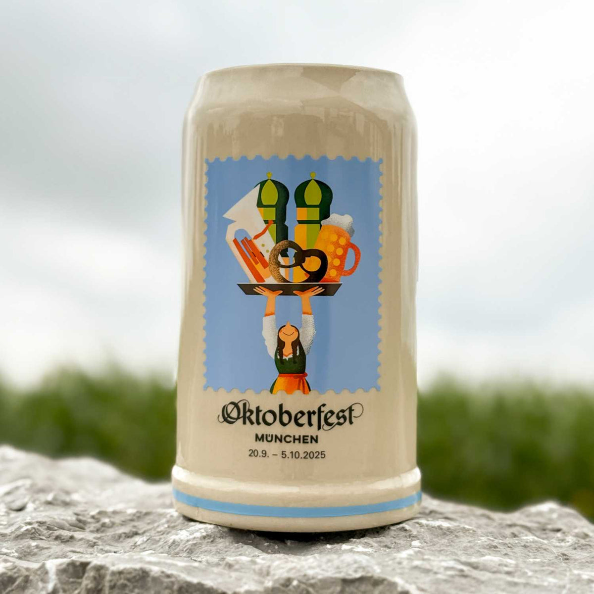 Offizieller Oktoberfestkrug 2025 mit bayerischem Motiv einer Bedienung, Bier und Brezn, hellbraun mit blauen Details.