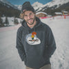 Lächelnder Mann mit Bart und Mütze im dunkelblauen Pumuckl Hoodie „Skifahren“ vor Winterlandschaft
