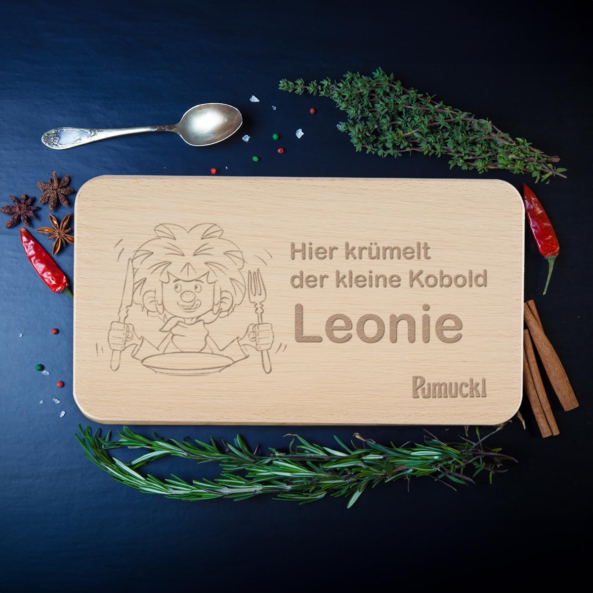 Pumuckl Frühstücksbrett aus Holz mit Wunschname Leonie, Lasergravur vom Kobold, umgeben von Kräutern.