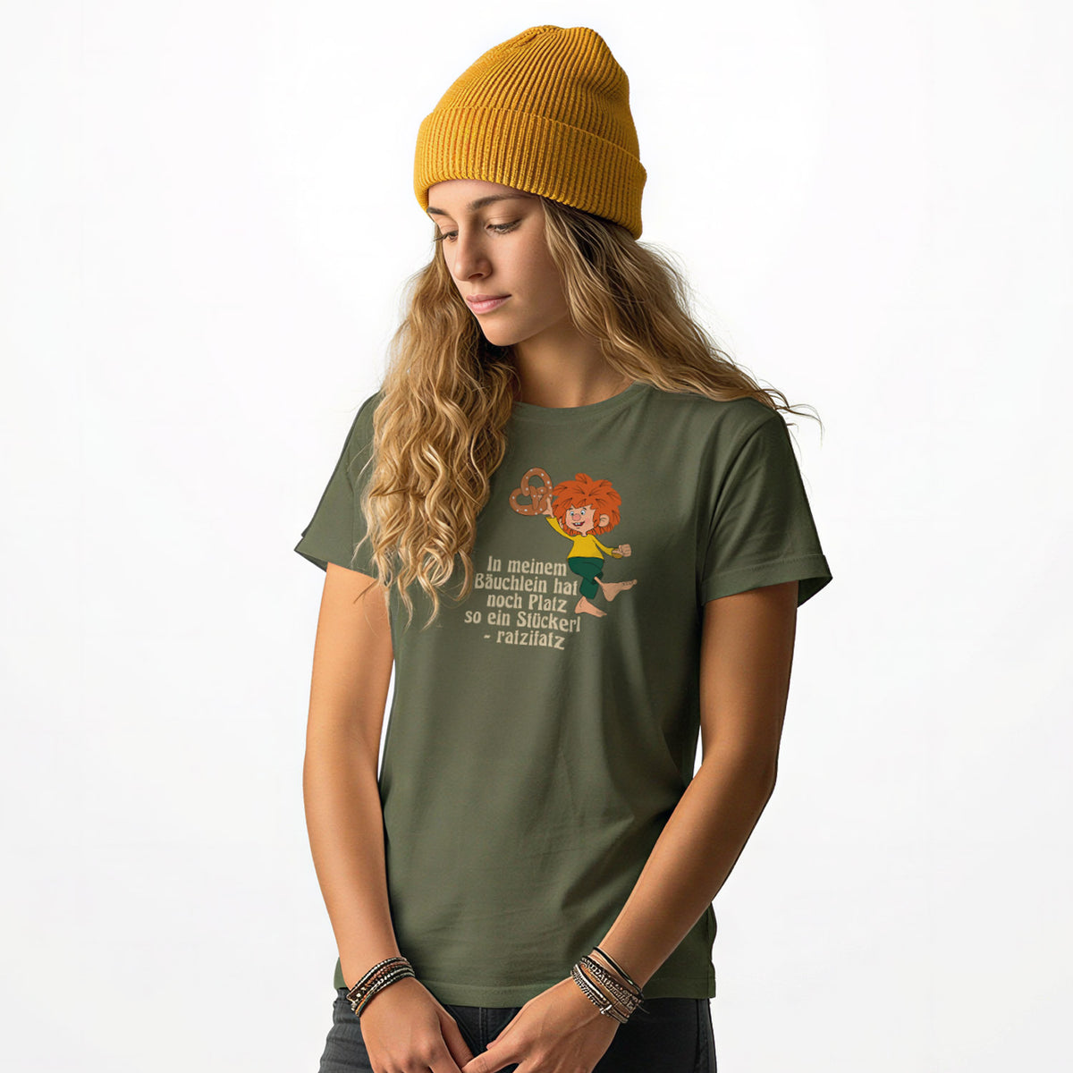 Junge Frau trägt olivgrünes Pumuckl Damen T-Shirt mit Aufdruck und gelber Beanie-Mütze