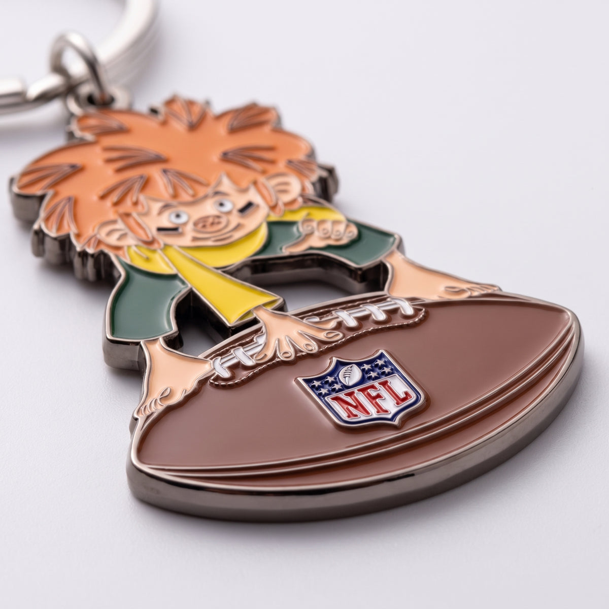 Detailaufnahme NFL x Pumuckl Schlüsselanhänger – erhabene Metallstege, glänzende Emaille und NFL-Logo auf dem Football